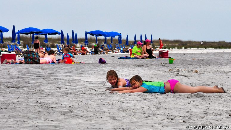 Sasha and her friend play in the sand at Ship Island beach
