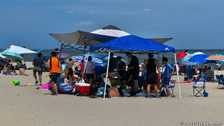 Beachgoers enjoy shade under a canopy at Sandy Hook’s Beach E in Gateway National Recreation Area