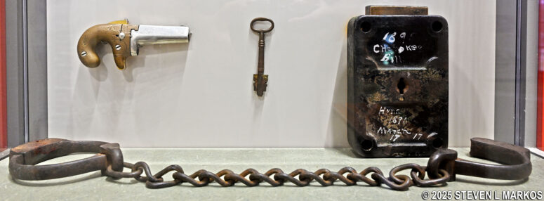 Cherokee Bill's shackles, lock and key, and guard's pistol on display at the Fort Smith National Historic Site Visitor Center