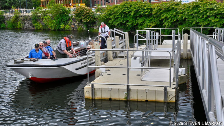 Participants on the Pawtucket Canal Boat Tour board the boat at the dock near the Swamp Locks, Lowell National Historical Park